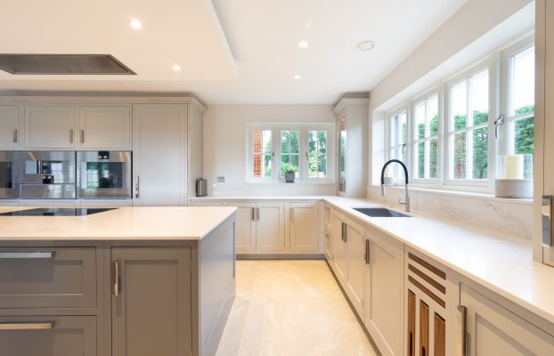 A bespoke kitchen with white cabinets and a sink.