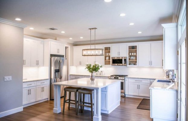 A kitchen with bespoke white cabinets featuring a center island.