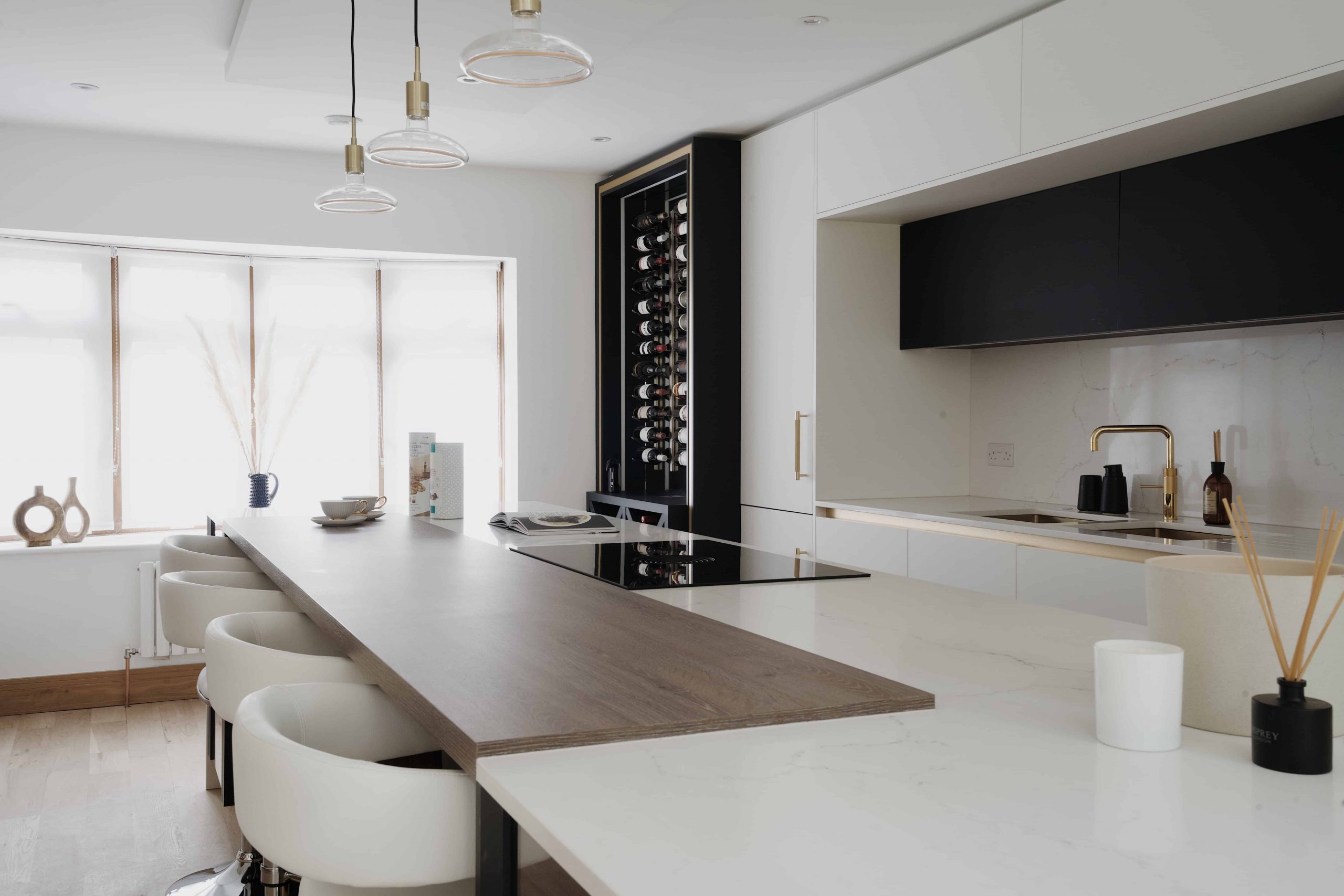 A bespoke kitchen in London featuring a wooden island and stylish black and white design.