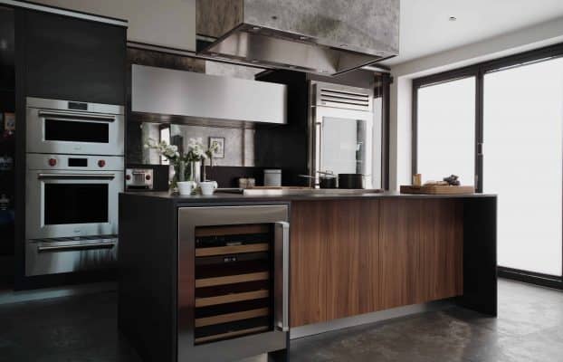 A stylish London kitchen featuring stainless steel appliances and bespoke wood works.