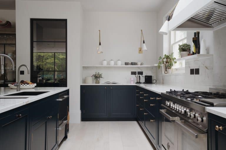 A bespoke kitchen with black cabinets and white counter tops in London.