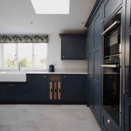 A bespoke kitchen in London featuring dark cabinets and a skylight.