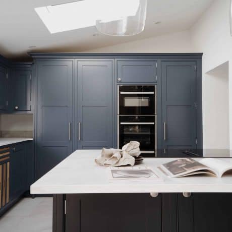 A London kitchen featuring dark blue cabinets and a skylight.