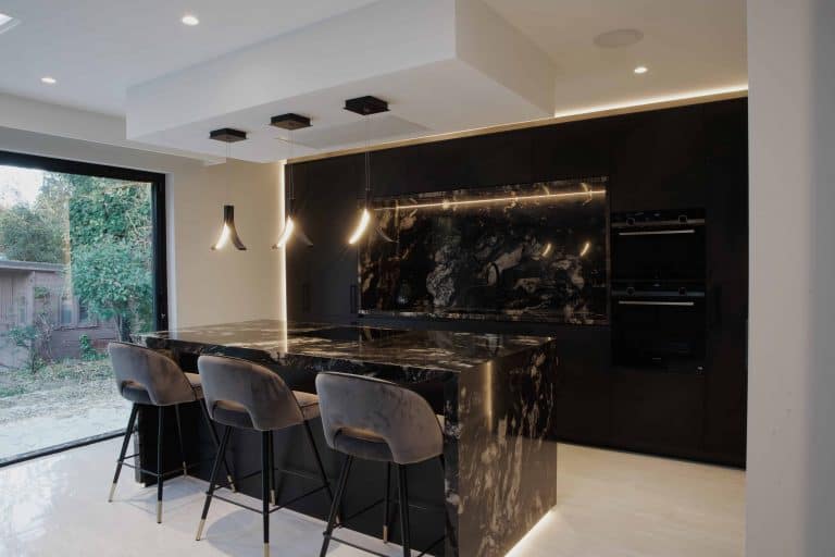 A bespoke kitchen in London showcasing black marble counter tops.